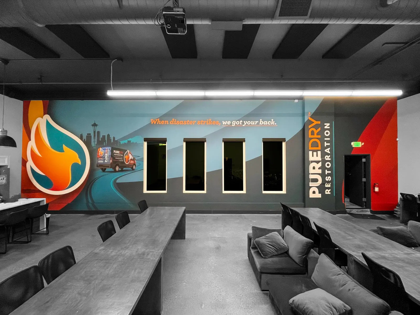 Office wall mural for PureDry Restoration with a Seattle skyline, phoenix logo and branded van wrapping around four windows