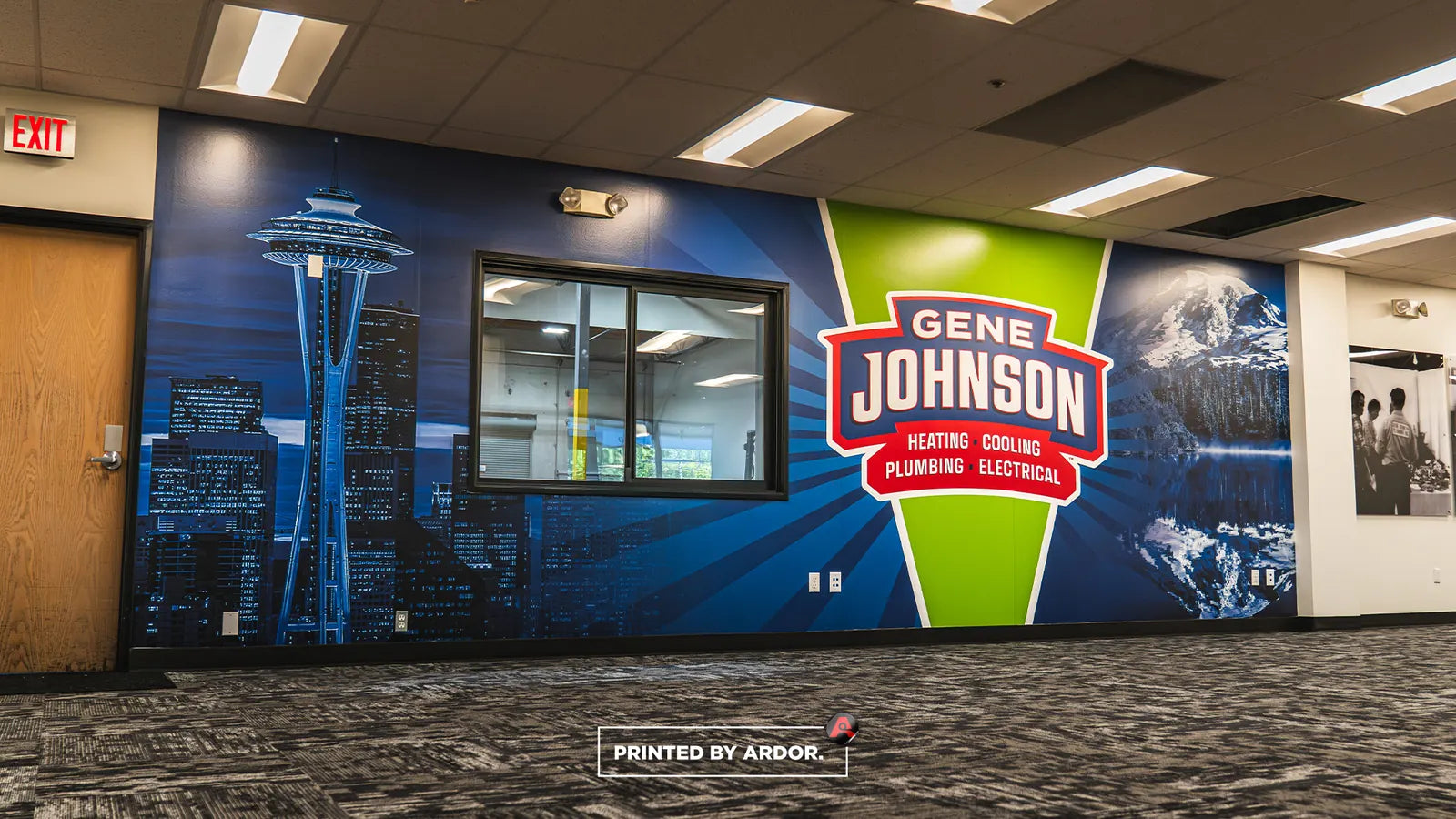 Office wall wrap with a blue Seattle skyline and Space Needle, mountain scenery and the Gene Johnson Heating Cooling Plumbing Electrical logo around an interior window